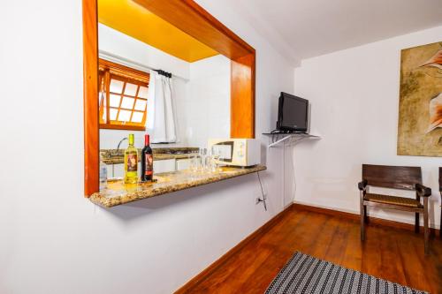 a room with a counter with bottles and a mirror at Putini Pousada e Hotel by OYO in São Roque