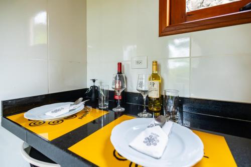 a kitchen counter with white plates and wine glasses at Putini Pousada e Hotel by OYO in São Roque