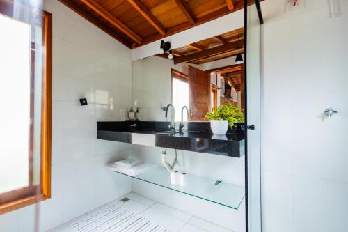 a bathroom with a sink and a mirror at Putini Pousada e Hotel by OYO in São Roque