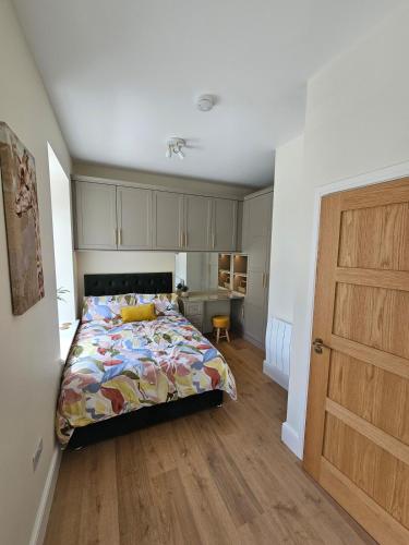 a bedroom with a bed and a wooden floor at Luxury studio apartment, Skipton in Skipton