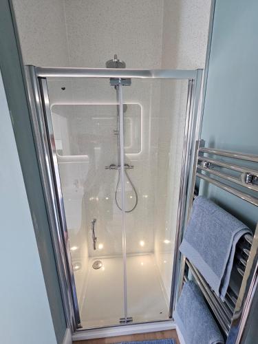 a shower with a glass door in a bathroom at Luxury studio apartment, Skipton in Skipton