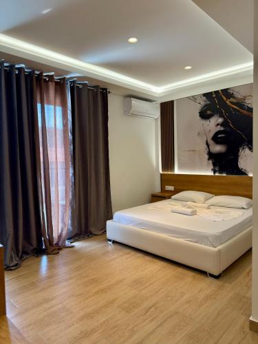 a bedroom with a bed and a painting on the wall at Fori's rooms in Himare