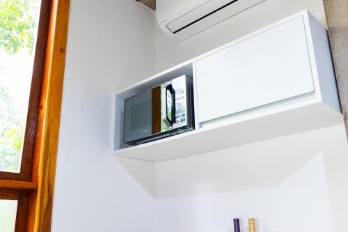 a television hanging on a wall in a room at Putini Pousada e Hotel by OYO in São Roque