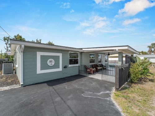 a small house with a patio and a fence at Relaxing modest bungalow- Mins to Beach - Pool - Yard in Englewood