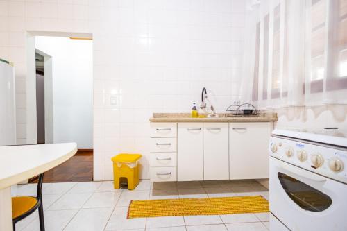 a white kitchen with a sink and a dishwasher at Putini Pousada e Hotel by OYO in São Roque