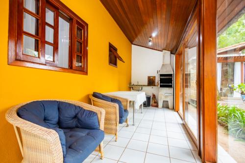 a living room with yellow walls and chairs and a table at Putini Pousada e Hotel by OYO in São Roque