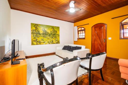 a living room with yellow walls and a white couch at Putini Pousada e Hotel by OYO in São Roque