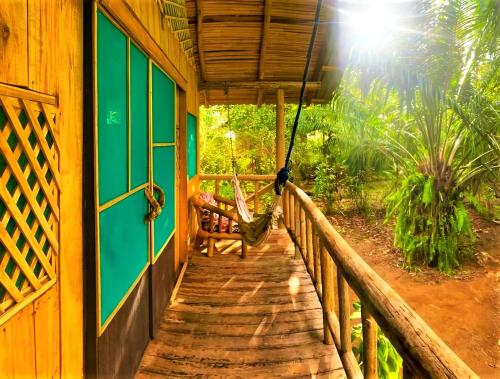 a porch of a house with a hammock on it at Ocean Forest Ecolodge in San Pedrillo