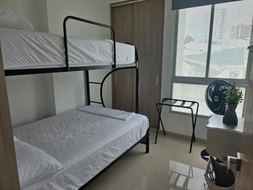 a bedroom with two bunk beds and a window at Apartamento amoblado en Cucuta in Los Patios