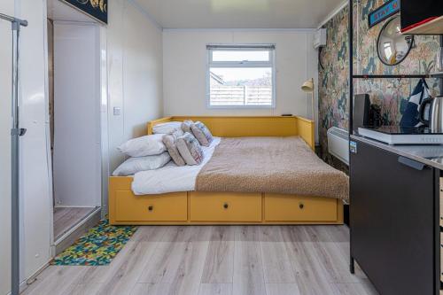 a bedroom with a yellow bed in a kitchen at Alaya Airways in Dolgellau