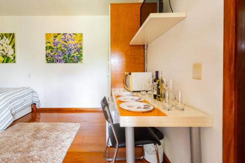a kitchen with a table with plates on it at Putini Pousada e Hotel by OYO in São Roque