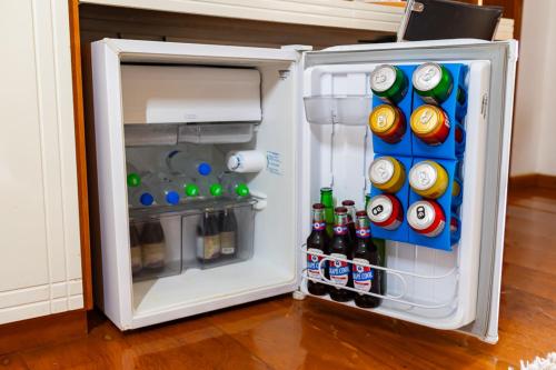 an open refrigerator with sodas and bottles of soda at Putini Pousada e Hotel by OYO in São Roque