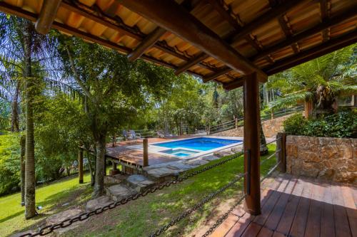 an estate with a swimming pool and a wooden deck at Putini Pousada e Hotel by OYO in São Roque