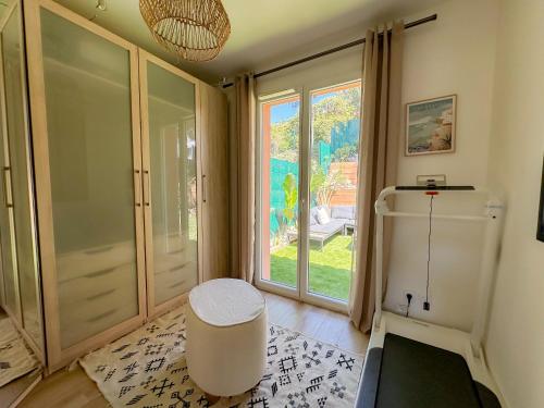 Cette chambre dispose d'un tabouret et d'une grande fenêtre. dans l'établissement Villa strelitzia, à Cavalaire-sur-Mer