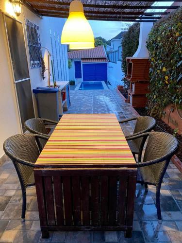 a wooden table and chairs on a patio at Casa do Rei Aroeira in Charneca