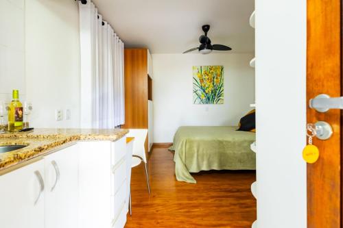 a kitchen with a sink and a bed in a room at Putini Pousada e Hotel by OYO in São Roque