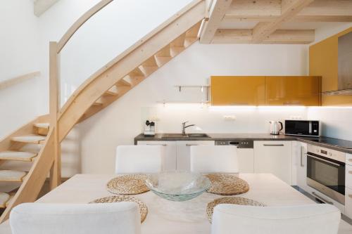 a kitchen with a table and chairs and a staircase at Apartmány Na Seníku in Třeboň