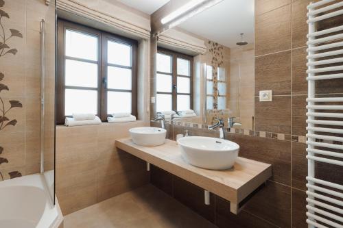 a bathroom with two sinks and a tub and a shower at Apartmány Na Seníku in Třeboň