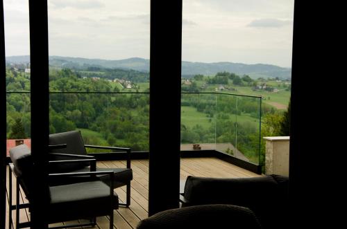 a room with two chairs and a balcony with a view at Skalna Osada in Istebna