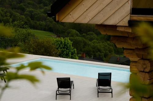 two chairs sitting next to a swimming pool at Skalna Osada in Istebna