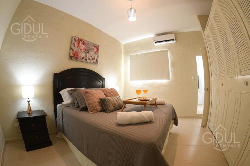 a bedroom with a bed and a table with two lamps at The Cozy Apartment in San Salvador