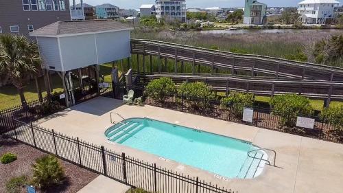 a swimming pool with a fence around it at Knot Fade Away in North Topsail Beach