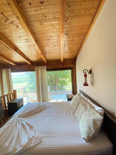 a bedroom with a bed with a wooden ceiling at Shasi Eco Lodge in Ambula