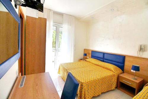 una camera con letto blu e coperta gialla di Hotel Eraclea a Lido di Jesolo