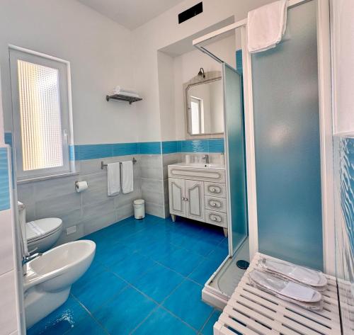 a blue bathroom with a shower and a sink at Palazzo Bonaventura 1906 in Forio d'Ischia