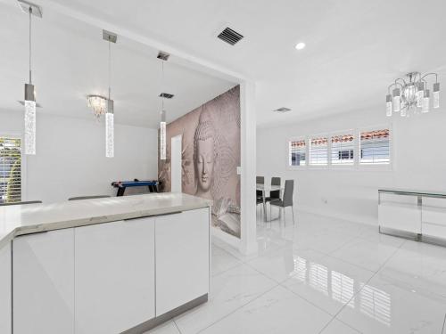 une cuisine aux murs blancs et une salle à manger dans l'établissement The Chill Sunny Casa Near Beaches, à Miami Lakes