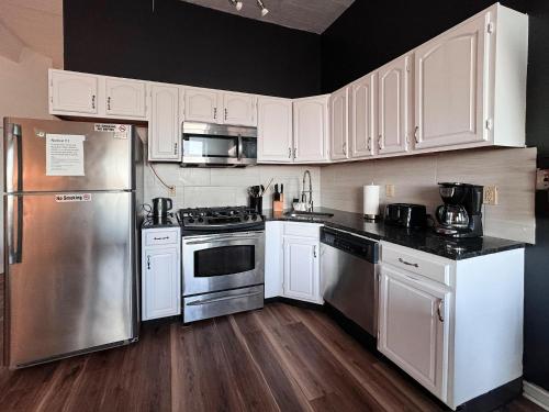 a kitchen with white cabinets and stainless steel appliances at Mega See NY Now - Midtown - Apt 1 & 2 Combo in Union City