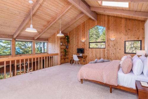 a bedroom in a log cabin with a bed and a desk at Charming 3 BD Family Home for 6 with Ocean Views & Trail Access in Sea Ranch