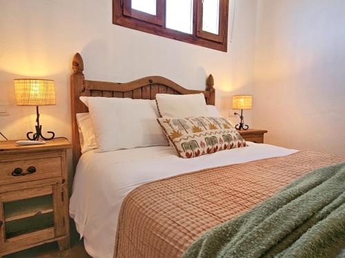a bedroom with a large bed with two lamps at Casas Rurales Los Molinos in Sanlúcar de Guadiana