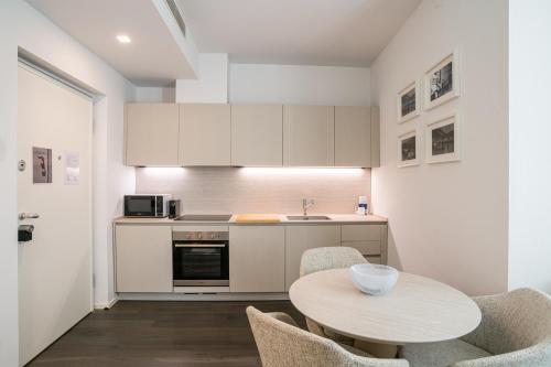 a kitchen with a table and chairs and a sink at Palazzo La Cortesella - Modern Design & Central Location in Como