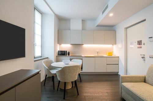 a kitchen and living room with a table and chairs at Palazzo La Cortesella - Modern Design & Central Location in Como