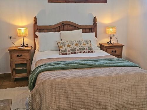 a bedroom with a large bed with two night stands at Casas Rurales Los Molinos in Sanlúcar de Guadiana