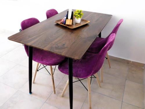 a wooden table with purple chairs around it at Depa privado Estadio GNP -Foro Sol-, Palacio de los Deportes in Mexico City