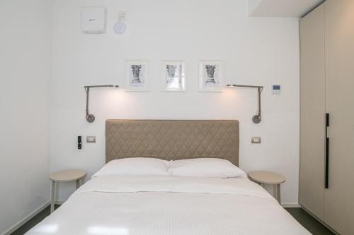 a bed in a room with two stools next to it at Palazzo La Cortesella - Modern Design & Central Location in Como