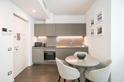 a kitchen with a table and chairs in a kitchen at Palazzo La Cortesella - Modern Design & Central Location in Como