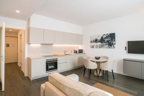 a kitchen and living room with a couch and a table at Palazzo La Cortesella - Modern Design & Central Location in Como
