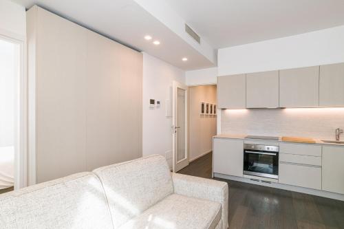 a living room with a couch and a kitchen at Palazzo La Cortesella - Modern Design & Central Location in Como