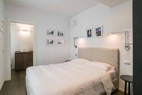 a white bedroom with a bed and a table at Palazzo La Cortesella - Modern Design & Central Location in Como
