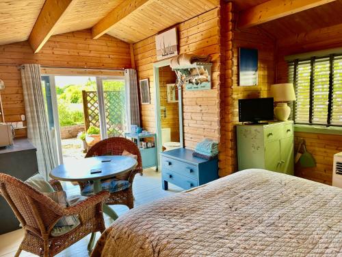 a bedroom with a bed and a table in a room at The Log Cabin in Wimborne Minster