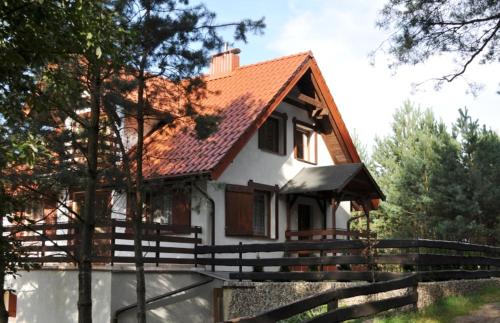 a small white house with a red roof at Wczasy na Kaszubach, balia, sauna, jezioro in Wąglikowice