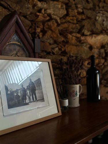 a picture of two men on a table with a bottle of wine at Alojamento Rural com Salamandra e AC - 10 min da Barragem do Sabor - Casa do Largo in Parada