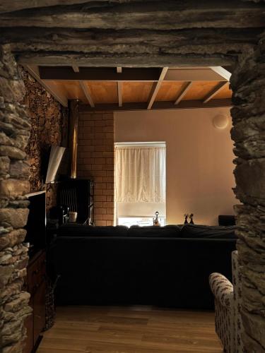a living room with a window and a bed at Alojamento Rural com Salamandra e AC - 10 min da Barragem do Sabor - Casa do Largo in Parada