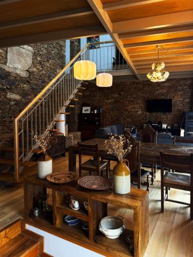 a dining room with wooden tables and a stone wall at Alojamento Rural com Salamandra e AC - 10 min da Barragem do Sabor - Casa do Largo in Parada