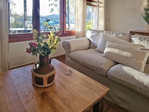 a living room with a couch and a table with flowers at Casas Rurales Los Molinos in Sanlúcar de Guadiana
