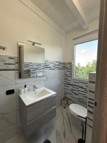 a bathroom with a sink and a toilet at 5 Zimmer Rooms ''Rosa'' in Siniscola