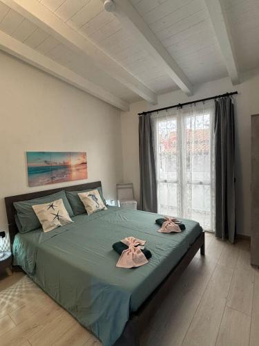 a bedroom with a large bed with two towels on it at 5 Zimmer Rooms ''Rosa'' in Siniscola